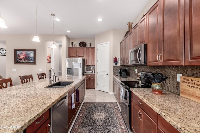 kitchen with a breakfast bar, sink, tasteful backsplash, decorative light fixtures, and stainless steel appliances