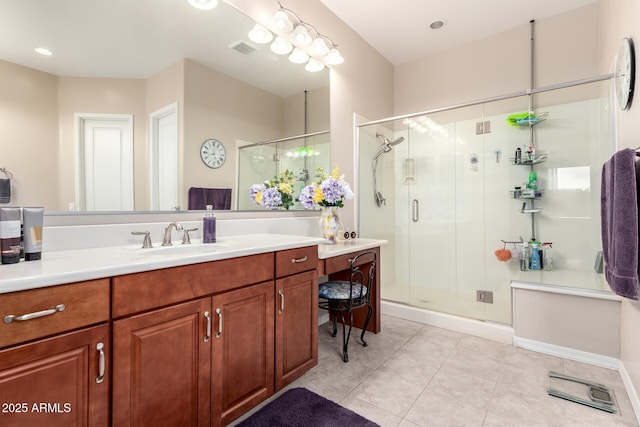 bathroom with a shower with door, vanity, and tile patterned flooring