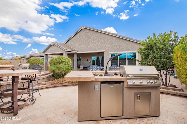 view of patio / terrace with an outdoor kitchen, area for grilling, and a bar