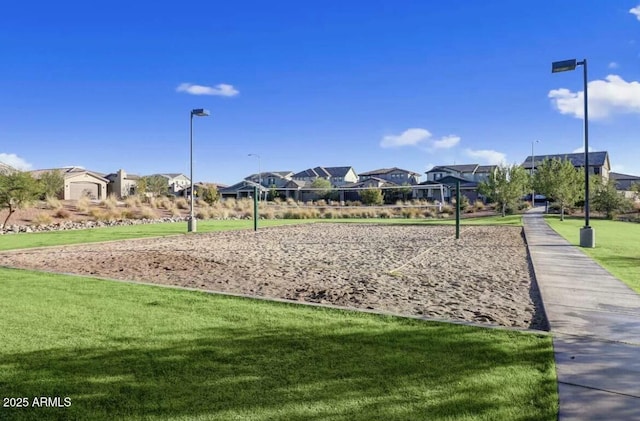 view of community with a lawn and volleyball court