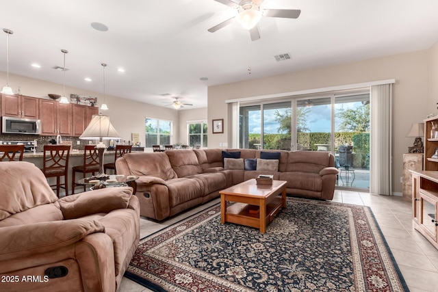 tiled living room with ceiling fan and a healthy amount of sunlight