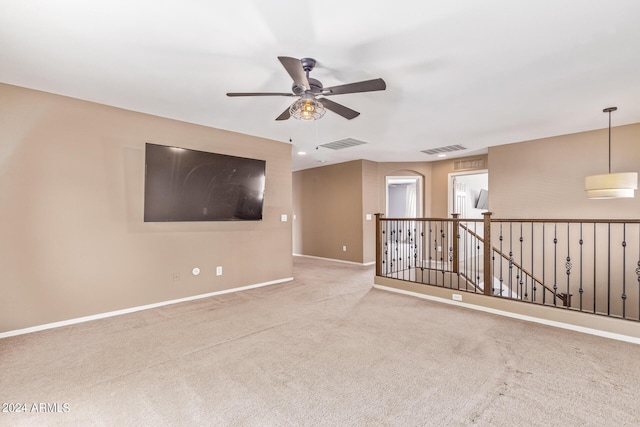 carpeted spare room featuring ceiling fan