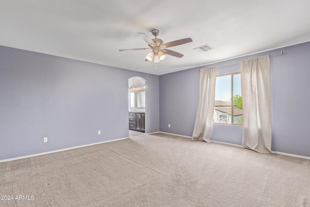 carpeted spare room featuring ceiling fan