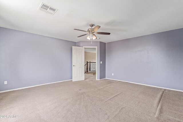 spare room with ceiling fan and light colored carpet