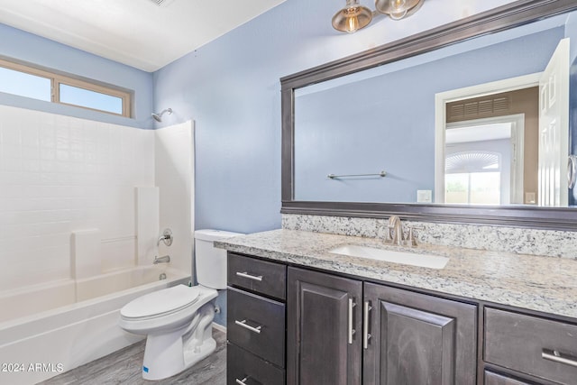 full bathroom with hardwood / wood-style floors, vanity, shower / bathtub combination, and toilet