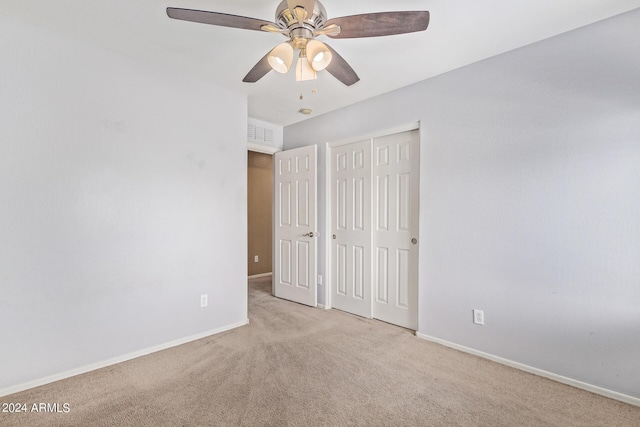 unfurnished bedroom with ceiling fan, a closet, and light carpet