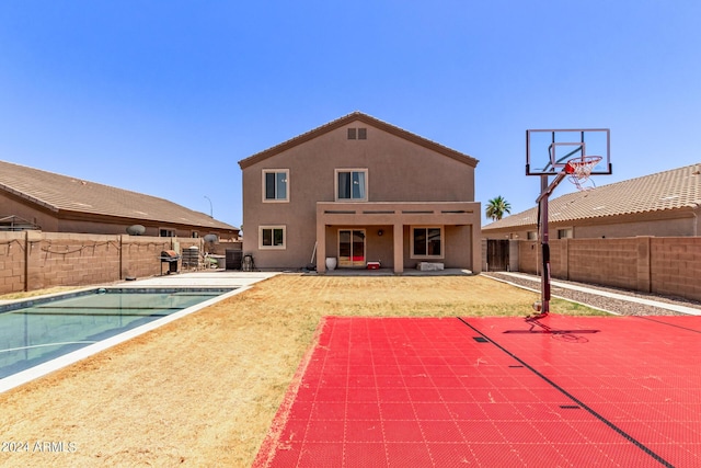 exterior space featuring a fenced in pool, a patio area, and basketball hoop