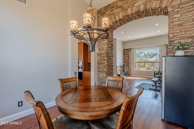 20809 N 17th St, Phoenix, AZ 85024 - dining space featuring arched walkways, dark wood-type flooring, ornate columns, a chandelier, and a high ceiling