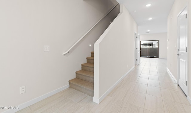 staircase with tile patterned floors, recessed lighting, and baseboards