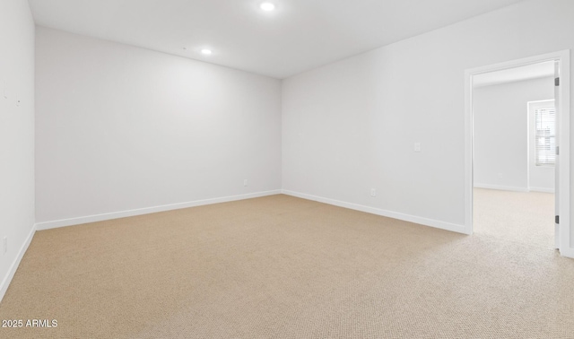 empty room featuring recessed lighting, baseboards, and light carpet