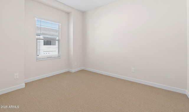 empty room with baseboards and light carpet