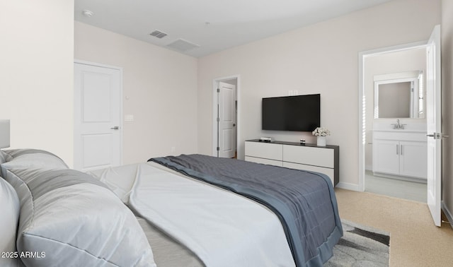 bedroom featuring carpet, baseboards, visible vents, a sink, and connected bathroom