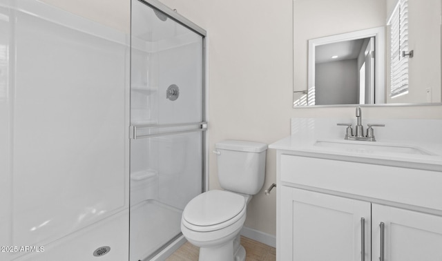 bathroom with a stall shower, toilet, and vanity