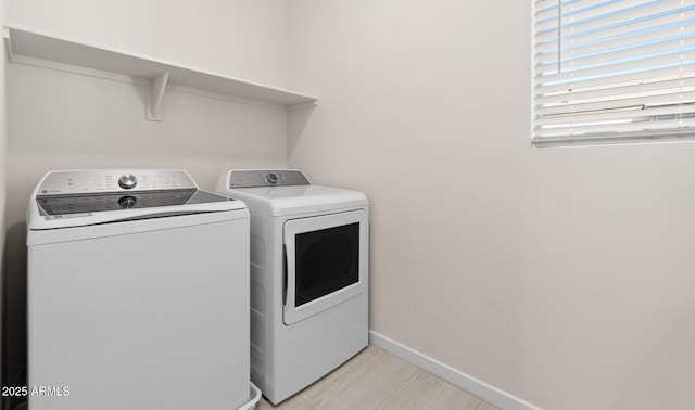 laundry room with washer and clothes dryer, laundry area, light wood-type flooring, and baseboards