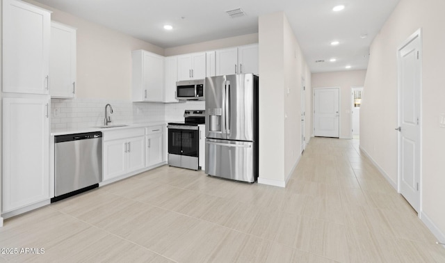 kitchen featuring a sink, tasteful backsplash, appliances with stainless steel finishes, and white cabinets