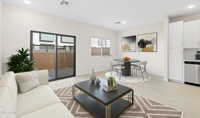 living room with light tile patterned floors, visible vents, baseboards, and recessed lighting