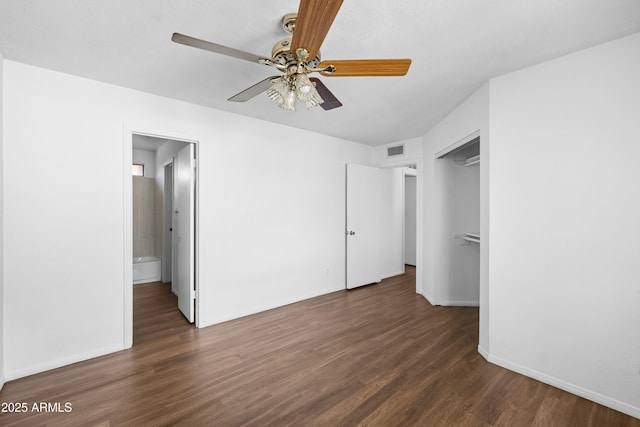 unfurnished bedroom with ensuite bath, dark wood-type flooring, a closet, and ceiling fan