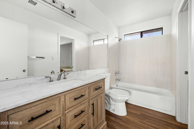 full bathroom featuring vanity, tiled shower / bath combo, toilet, and hardwood / wood-style flooring