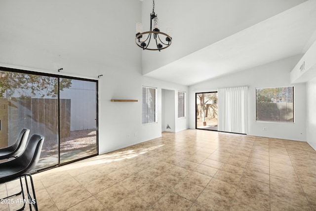 unfurnished living room featuring light tile patterned flooring, vaulted ceiling, and a chandelier