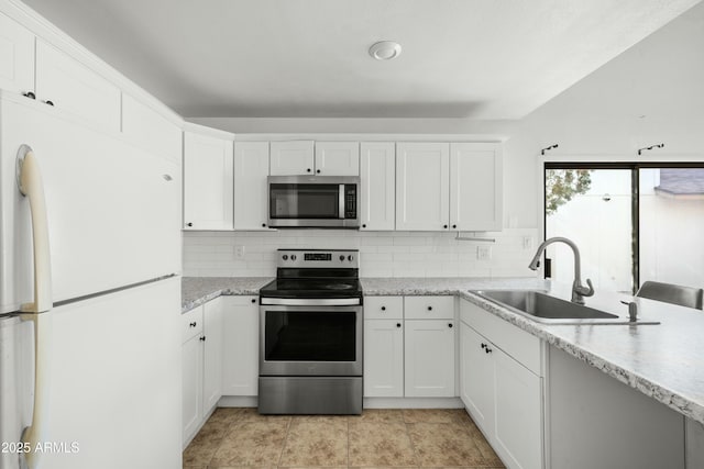 kitchen featuring appliances with stainless steel finishes, sink, white cabinets, and backsplash