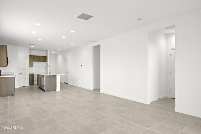 unfurnished living room featuring sink and light tile patterned floors