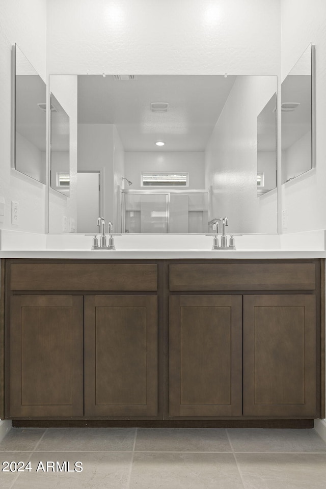 bathroom with tile patterned floors, vanity, and walk in shower