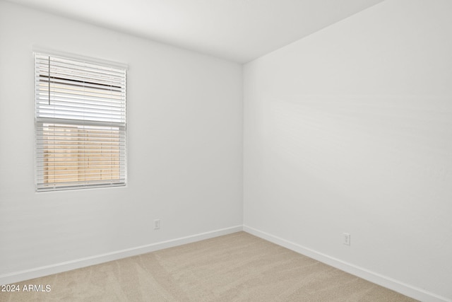 unfurnished room featuring light colored carpet