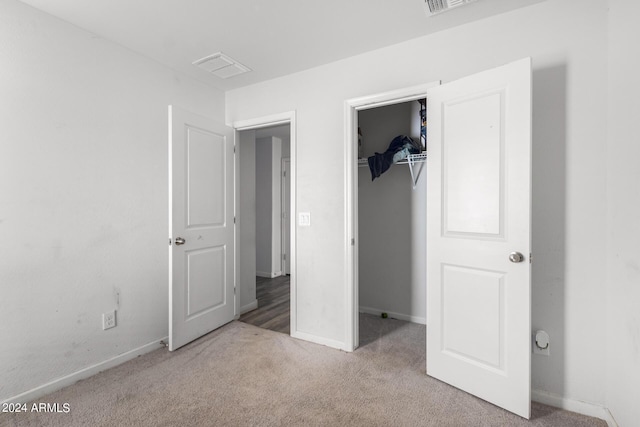 unfurnished bedroom featuring light colored carpet and a closet