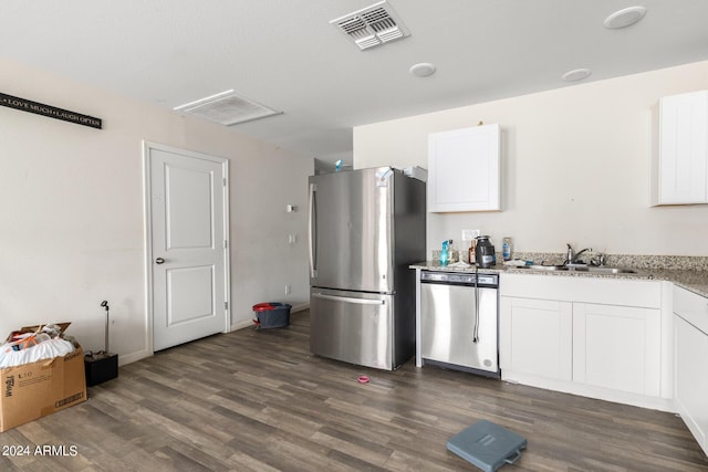 kitchen with sink, dark wood-type flooring, stainless steel appliances, and white cabinets