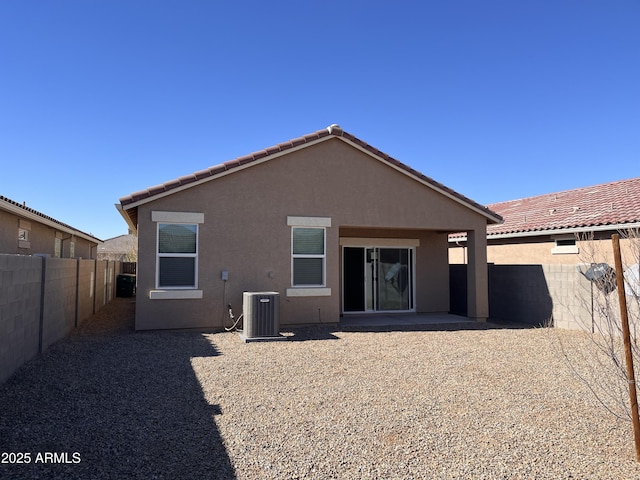 back of property with central air condition unit and a patio