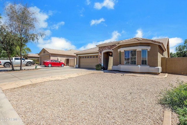 1669 E Santa Fiore St, San Tan Valley, AZ 85140 - view of front of house featuring an attached garage, concrete driveway, stucco siding, a tile roof, and fence