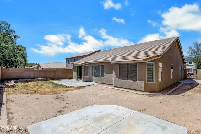 1669 E Santa Fiore St, San Tan Valley, AZ 85140 - back of property with a tiled roof, a fenced backyard, a patio, and stucco siding