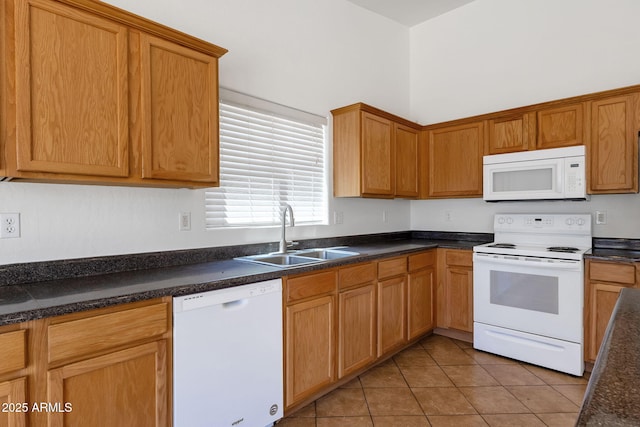 1669 E Santa Fiore St, San Tan Valley, AZ 85140 - kitchen with white appliances, a sink, light tile patterned floors, dark countertops, and brown cabinetry