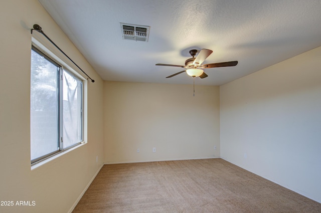 empty room with ceiling fan, a textured ceiling, and carpet flooring