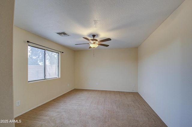 carpeted spare room with ceiling fan and a textured ceiling