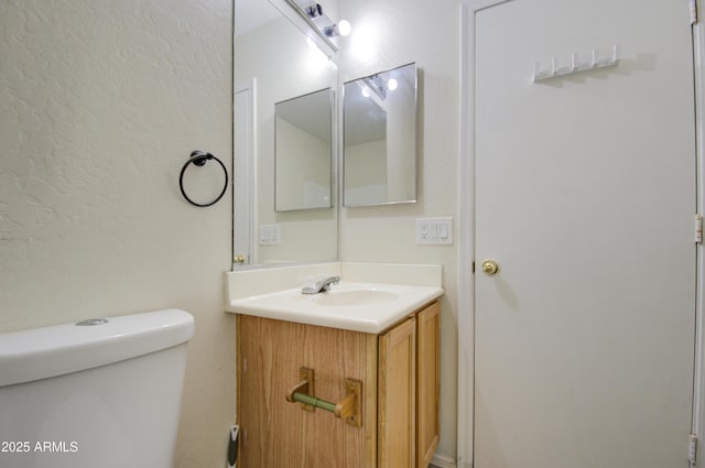 bathroom featuring toilet and vanity