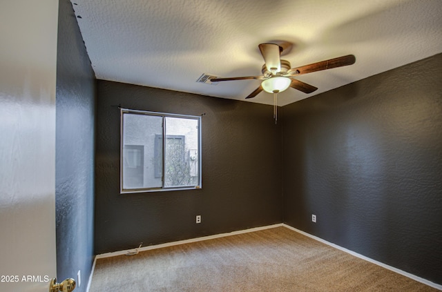 spare room with ceiling fan, a textured ceiling, and carpet flooring