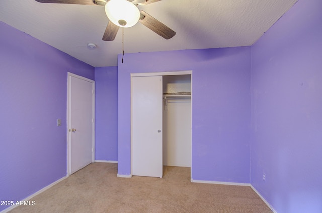 unfurnished bedroom with ceiling fan, a textured ceiling, a closet, and light carpet