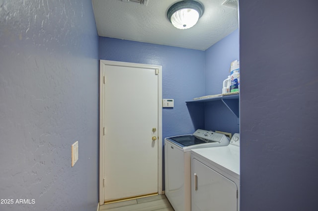 washroom featuring washer and dryer and a textured ceiling