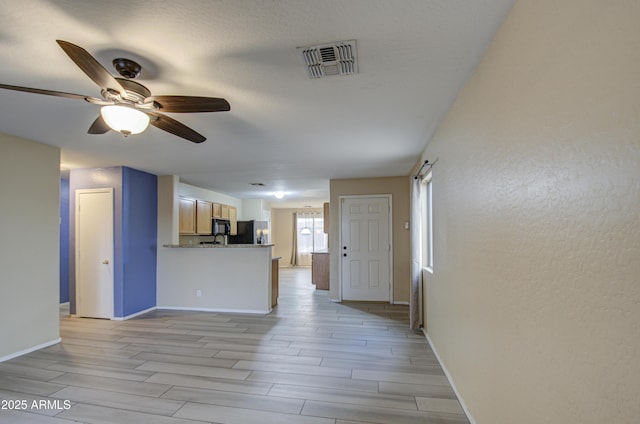 unfurnished living room with ceiling fan and light wood-type flooring