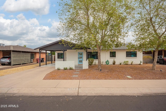 view of front of house featuring a carport, concrete driveway, and brick siding