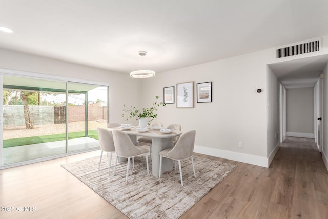 dining area with visible vents, baseboards, and wood finished floors