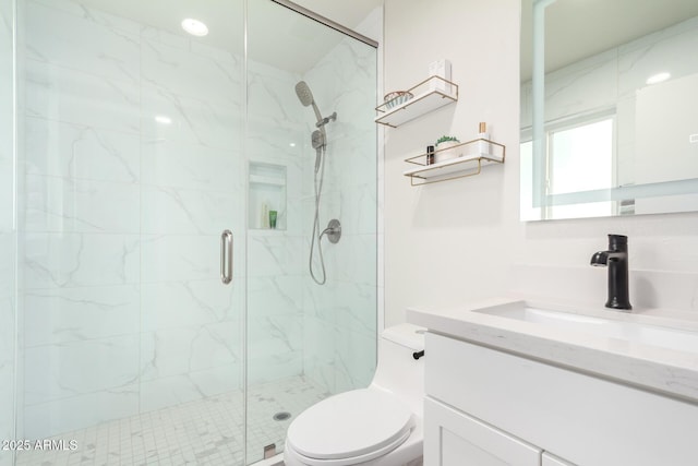 full bath featuring vanity, toilet, and a marble finish shower