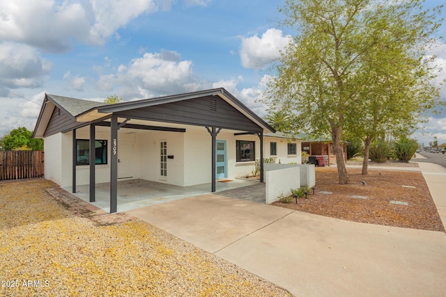 view of front of property with a carport, fence, and brick siding