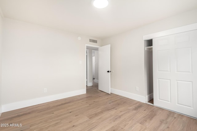 unfurnished bedroom featuring a closet, baseboards, and wood finished floors