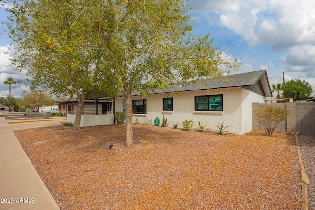 ranch-style home with brick siding and fence