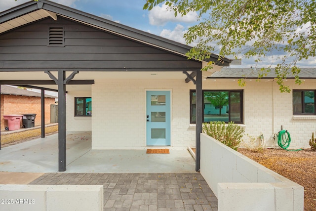 exterior space with an attached carport and brick siding