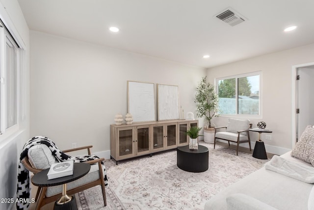 living area with wood finished floors, recessed lighting, visible vents, and baseboards