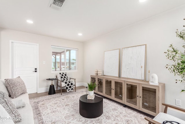 living area featuring light wood-type flooring, visible vents, baseboards, and recessed lighting