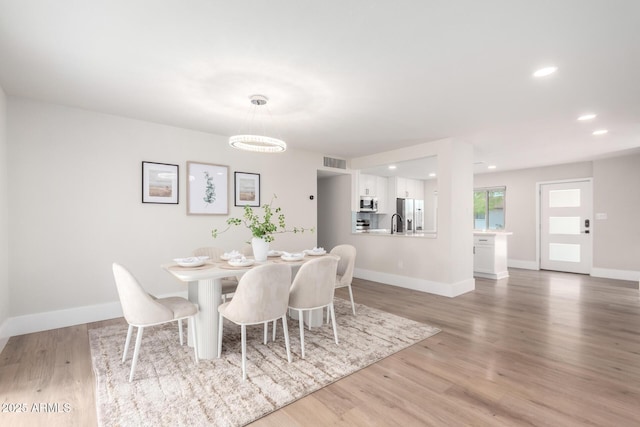 dining room with recessed lighting, visible vents, light wood-style flooring, and baseboards